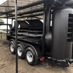 racks inside of double bbq pit on gooseneck trailer